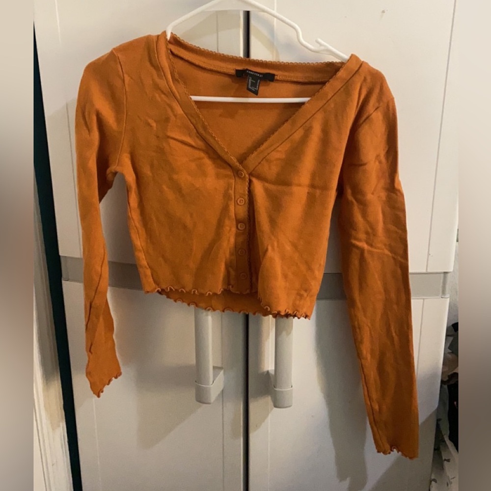 Orange colored long sleeve crop top